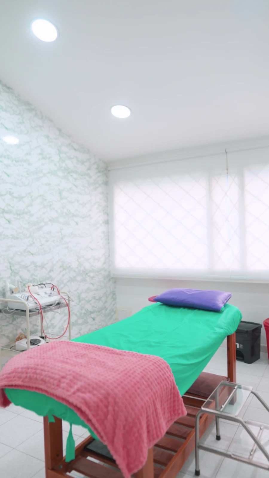 Cabina de pared verde con camilla y equipos de Victoria’s Revitalize